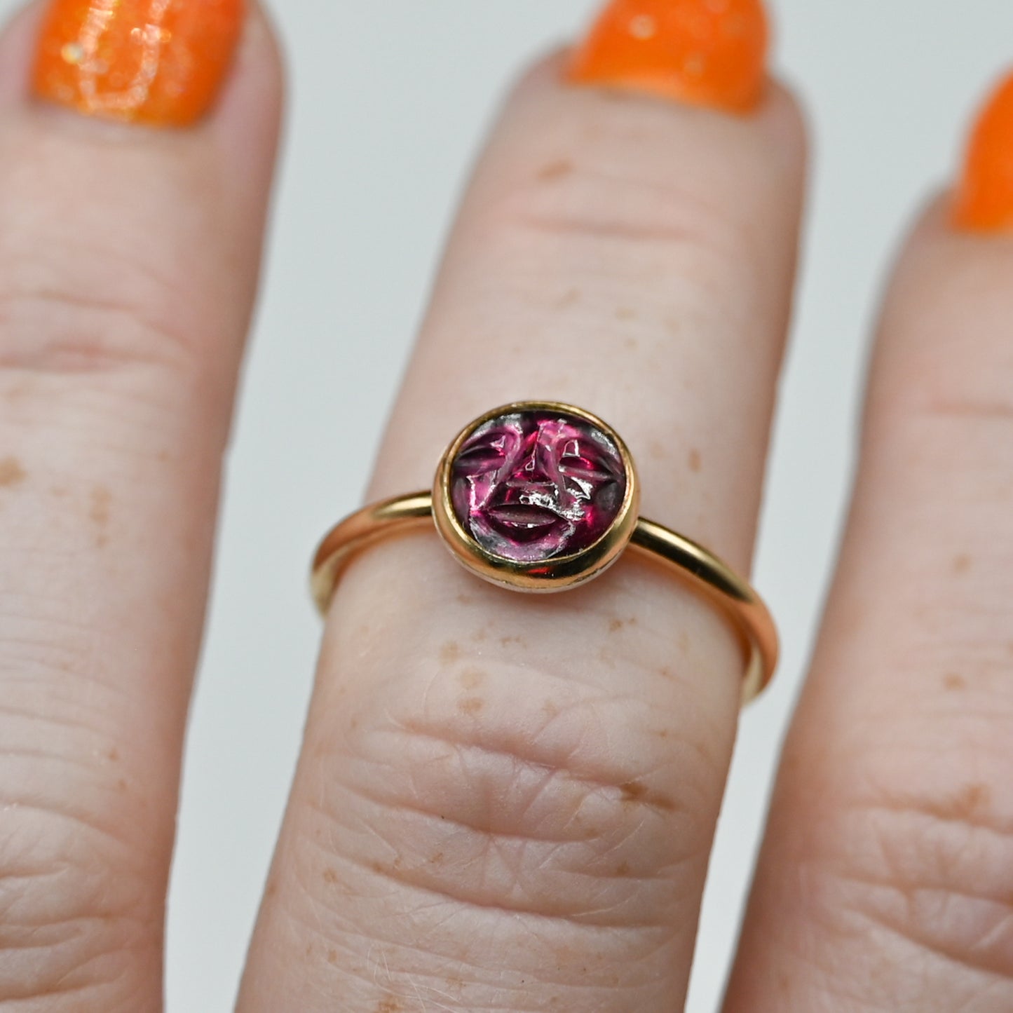 Gold fill garnet carved face size 7